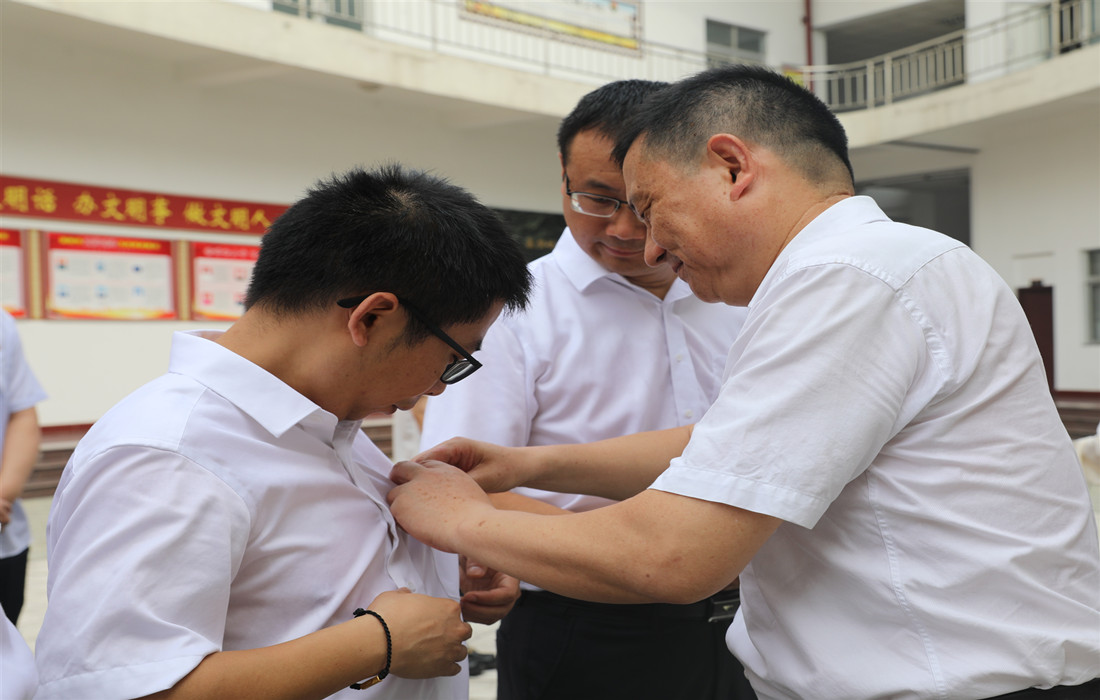 3.为新党员佩戴党徽.jpg 3.为新党员佩戴党徽.jpg