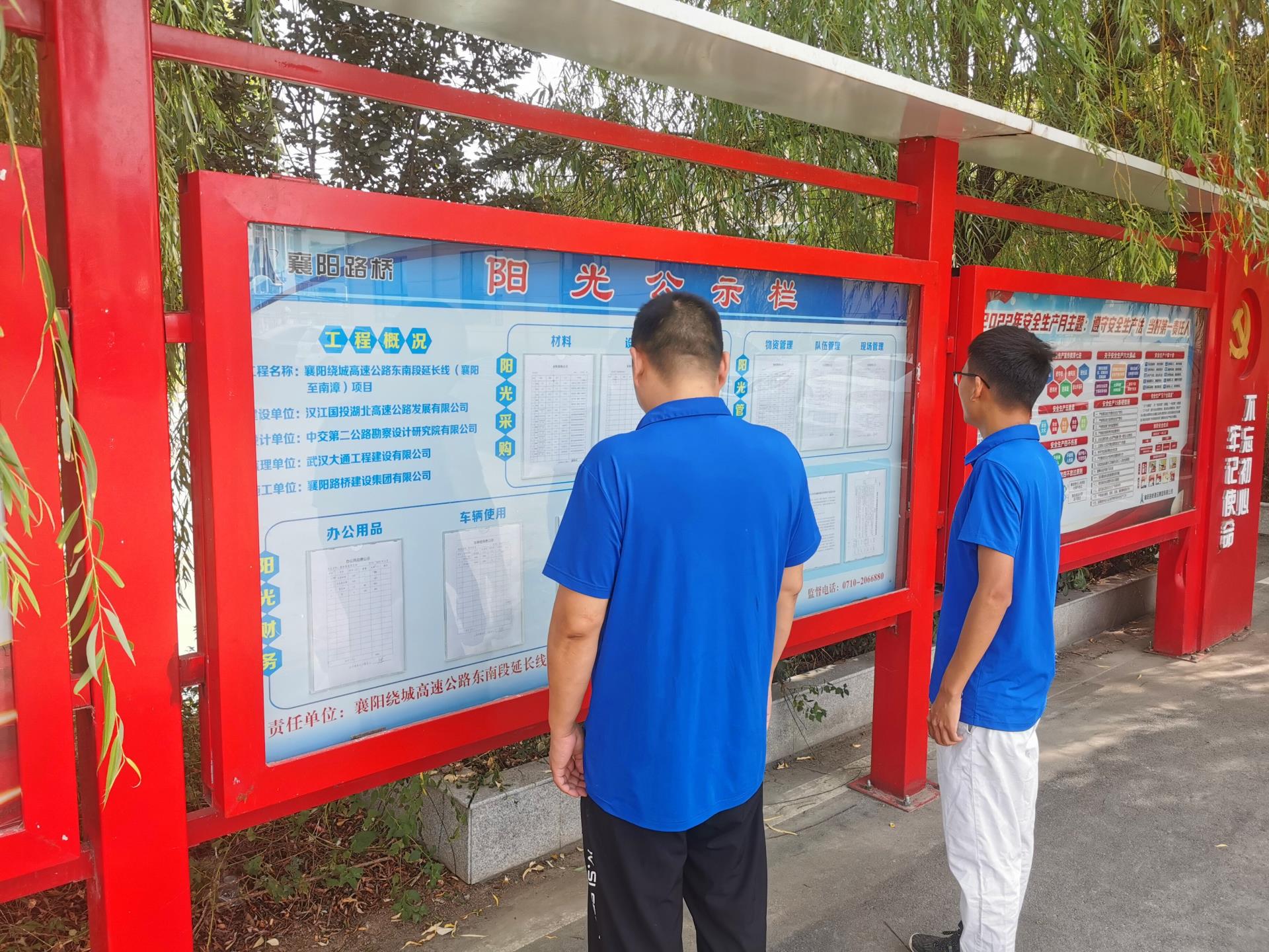 图2：项目员工驻足观看阳光公示栏.jpg