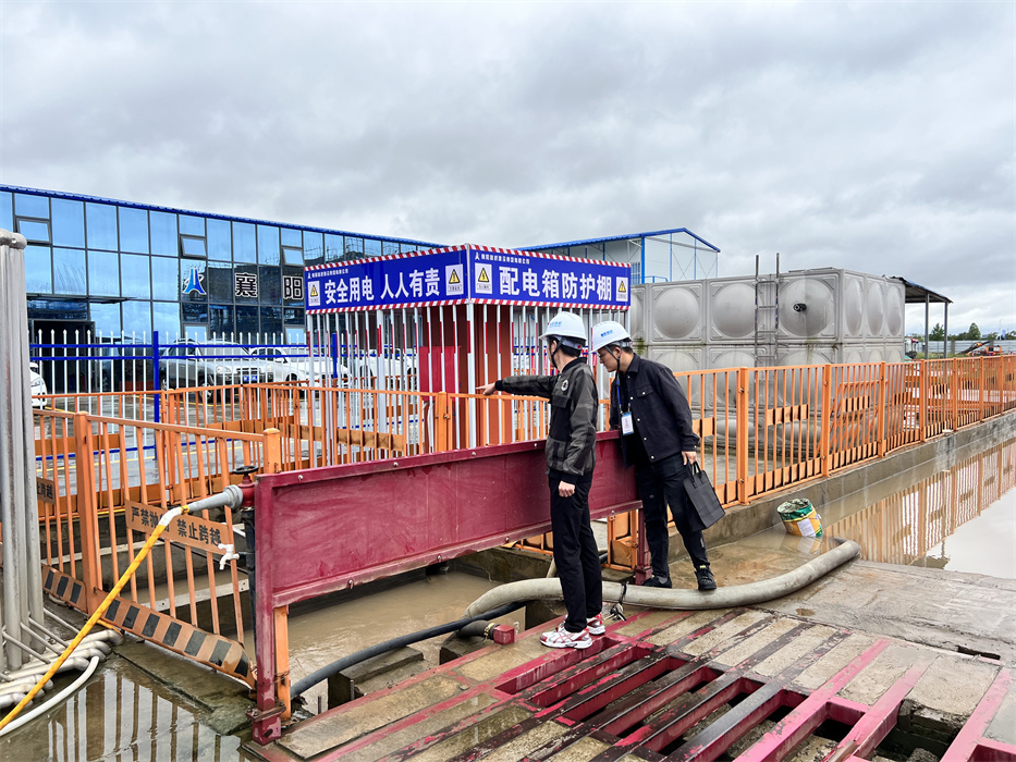 图为纪检监督员查看襄阳五中实验小学项目现场防汛情况.jpg
